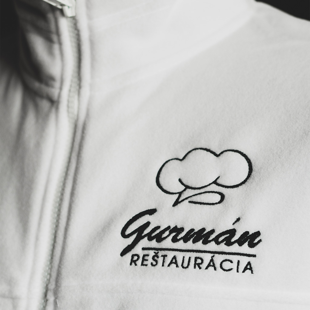 Vyšívané logo na bielej fleece mikine pre reštauráciu a zamestancov. Biela pracovná mikina.