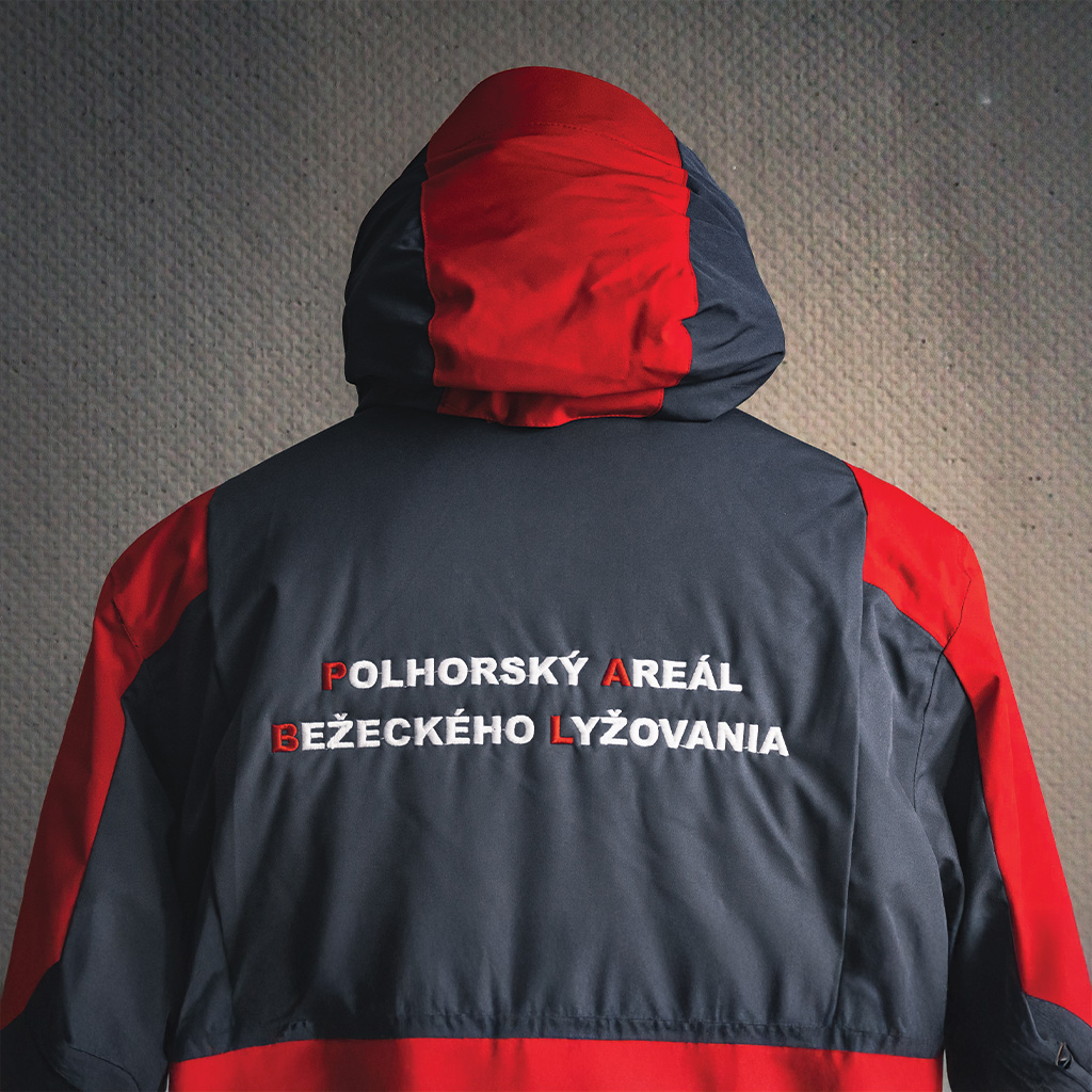 Vyšívaný text na bunde. Pracovné oblečenie s personalizovaným dizajnom na chrbte.