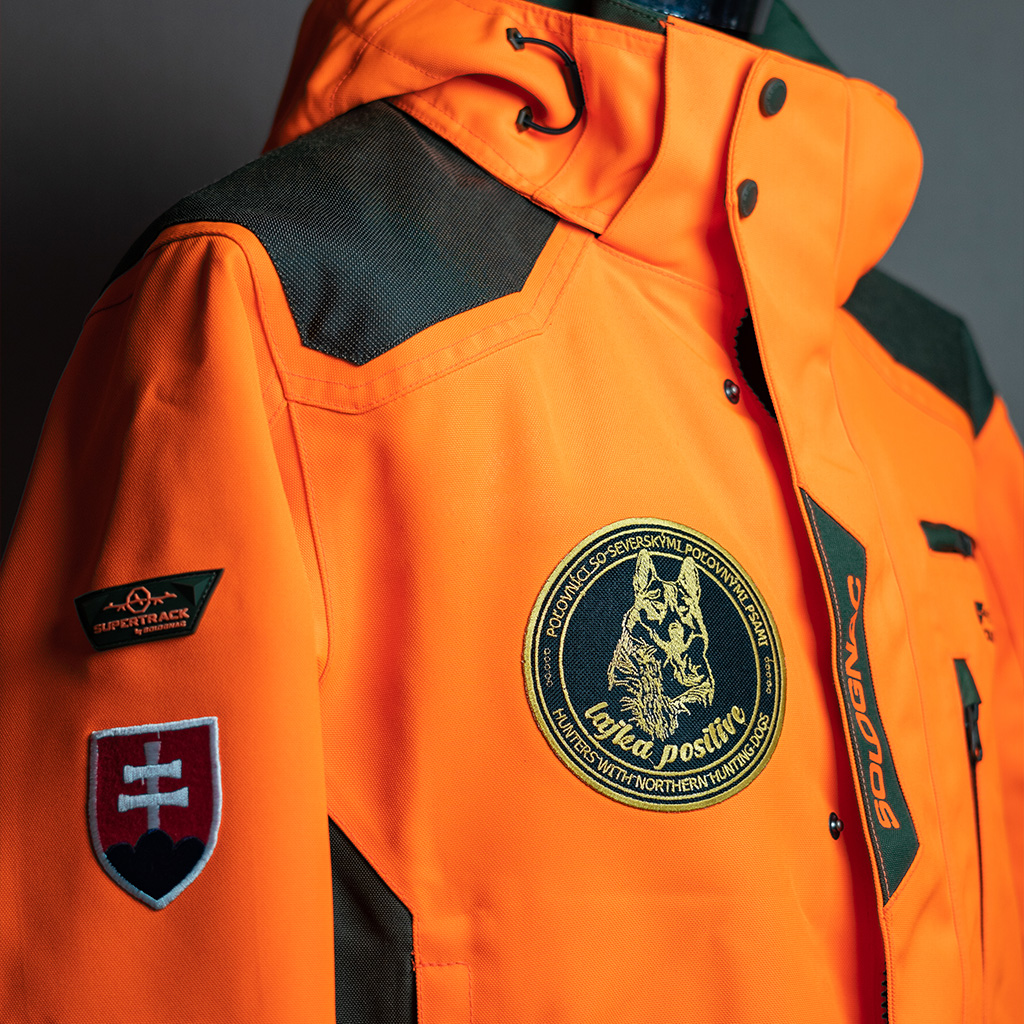 Oranžová poľovnícka bunda s nášivkou, odolná voči oderu.