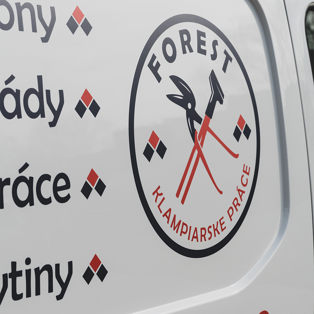 Reklamný polep na firemnom automobile. Biela dodávka s grafikou. Logo klampiarskej firmy. Klampiarske práce.
